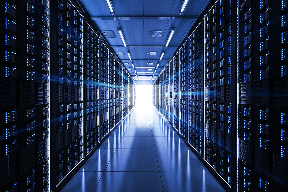 A dimly lit data centre aisle lined with server racks and blue indicator lights
