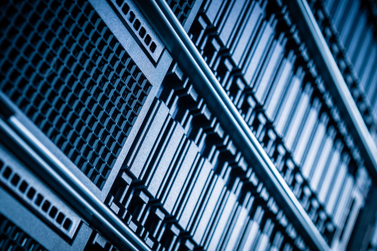 Close-up of rows of storage drive bays in a server rack, lit in cool blue tones